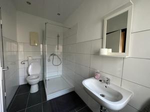 a white bathroom with a toilet and a sink at Eva's Hostel - Self Check-In & Room Just For You Alone in Düsseldorf