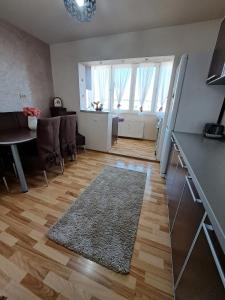 uma cozinha e sala de estar com uma mesa e um tapete em Apartament Raul em Sânmartin