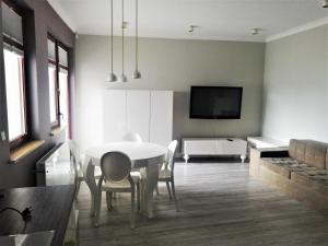 a living room with a white table and chairs at Kwiatowa Bryza in Gdańsk