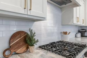 a kitchen with white cabinets and a stove top oven at Charming Cottage built in 2019 in Lafayette