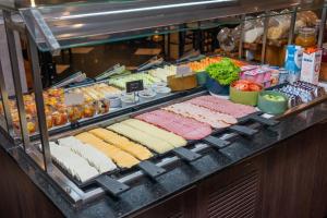 ein Buffet mit verschiedenen Arten von Fleisch und Gemüse in der Unterkunft Slaviero Guarulhos Aeroporto in Guarulhos