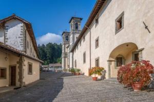 an alley in a building with potted plants and a tower at Casa di Adele in Pratovecchio
