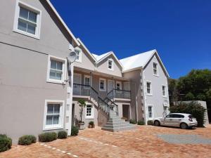 a white house with a car parked in front of it at a Hout Bay Gem - great FAMILY duplex value in Hout Bay