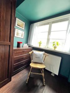 una silla en una habitación con ventana y radiador en Strandmuschel, en List