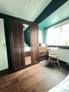 Strandmuschel في ليست: غرفة نوم مع خزانة خشبية كبيرة وكرسي