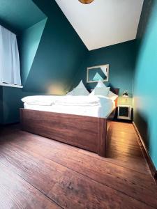 duże łóżko w pokoju z niebieską ścianą w obiekcie Strandmuschel w mieście List