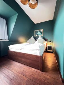 una camera con un grande letto con una parete blu di Strandmuschel a List