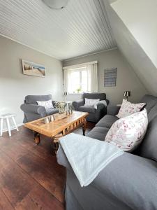 a living room with couches and a wooden table at Strandmuschel in List