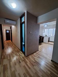 um quarto vazio com piso de madeira e uma porta aberta em Apartament Raul em Sânmartin