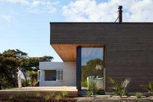 a modern house with a large glass window at Sister's Sanctuary in Raglan