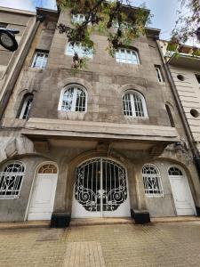 a large stone building with white doors and windows at HOM l Departamento 3PAX A l A Lastarria in Santiago