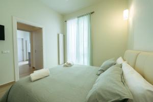 a white bedroom with a large bed with pillows at In centro apartment in Palermo