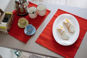 a table with two plates of food and cups at In centro apartment in Palermo
