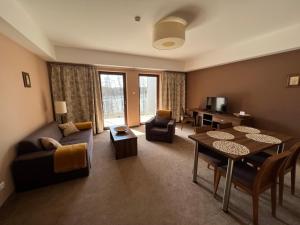 salon z kanapą i stołem w obiekcie Apartament Perła nr 19 nad Jeziorem Pluszne w mieście Mierki