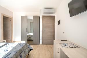 1 dormitorio con 1 cama y escritorio con TV en Villa Solymar en Alghero