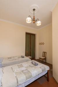 1 dormitorio con 2 camas y lámpara de araña en Tamari Guest House, en Telavi