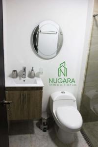 a bathroom with a toilet and a sink and a mirror at Apartamento Super-Confortable in Zipaquirá