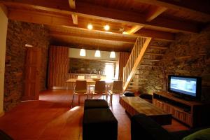 a living room with a television and a table with chairs at Casa do Moleiro in Mirandela