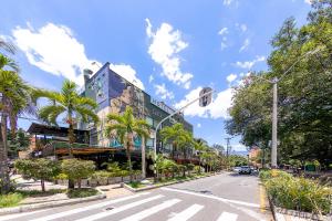 una calle de la ciudad con palmeras y un edificio en Hotel Ayenda Palo Alto, en Medellín