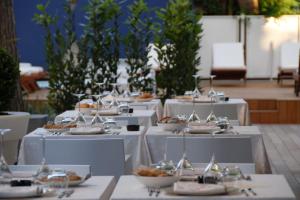 un jeu de tables avec des assiettes et des bols de nourriture dans l'établissement Atmosfere Milano Marittima, à Milano Marittima
