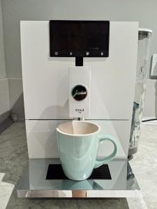 a coffee machine with a cup on a counter at Apartamenty Wiejska 126 in Sosnowiec