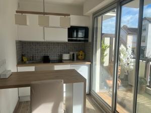 una cucina con tavolo in legno e finestra di Appartement hyper centre de Cabourg avec balcon a Cabourg