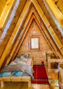een slaapkamer in een blokhut met een bed erin bij Cottage Bumblebee in Žabljak