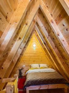 a bed in the attic of a wooden cabin at Cottage Bumblebee in Žabljak