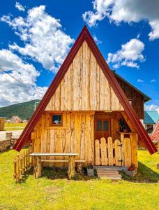 een houten hut met een bank ervoor bij Cottage Bumblebee in Žabljak