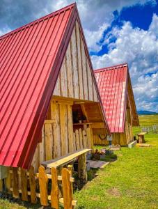 a wooden barn with a red roof and a bench at Cottage Bumblebee in Žabljak