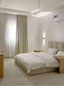 a white bedroom with a bed and a window at Luxury and Modern Hotel Apartments in Mudhainib in Medina +62 photos