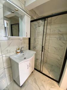 a bathroom with a white sink and a shower at Sisli Central Apartments in Istanbul