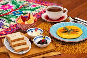 una mesa con platos de comida y una taza de café en Tominejo Ecolodge Casas en los árboles, en Neira