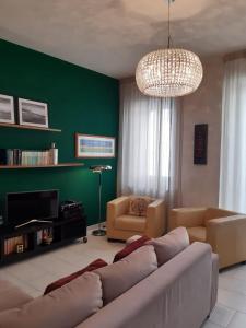 Una sala de estar con un sofá y una pared verde. en Basilicò, en Caltagirone