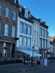 een groep gebouwen op een straat met tafels en stoelen bij W Y C K - E N D boutique b&b in Maastricht