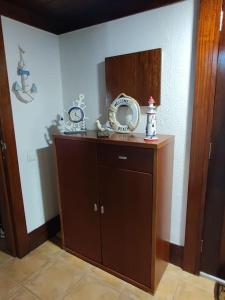 a room with a wooden cabinet and a mirror at Sunset Troia Beach in Troia