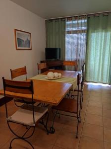 a dining room with a wooden table and chairs at Sunset Troia Beach in Troia