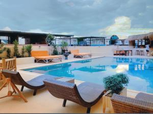 a large swimming pool with chairs and tables on a building at Chiang Mai luxury condo hidden in the city in Chiang Mai
