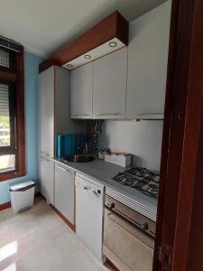 a kitchen with white cabinets and a stove top oven at Sunset Troia Beach in Troia