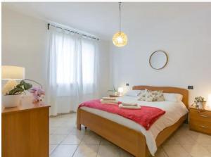 a bedroom with a large bed with a red blanket at Casa Ulivi Rosso in Rivoltella