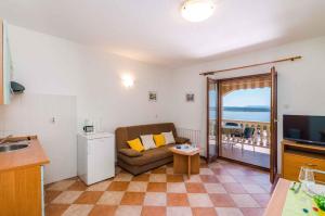 a kitchen and a living room with a couch and a television at One-Bedroom Apartment Crikvenica 6 in Dramalj