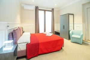 1 dormitorio con 1 cama roja y 1 silla en suebi appartament and rooms, en Termoli