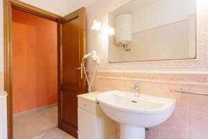 un baño con lavabo y espejo en CASA ELENA, en Alghero 4 fotos más