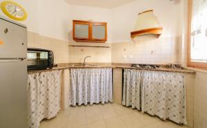 una cocina con fregadero y refrigerador en CASA ELENA, en Alghero