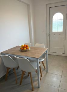 a dining room table with a bowl of oranges on it at Bouvegio Apartments Vera in Afantou