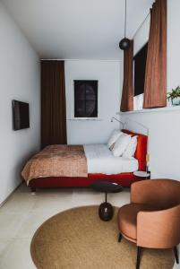 een slaapkamer met een bed en een stoel bij Visite in Evergem
