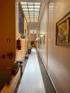 un couloir vide dans un bâtiment avec des plantes en pot dans l'établissement HOTEL El INDIO, à Otavalo