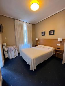 una camera d'albergo con un grande letto e una finestra di Hotel Ramona a Laredo