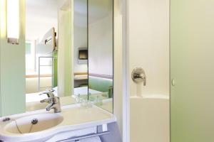 a bathroom with a sink and a mirror at ibis budget London Hounslow in Hounslow