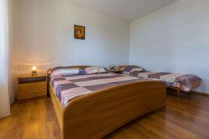 two beds in a room with wooden floors at Apartment in Dramalj 5753 in Dramalj